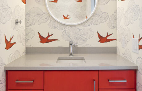 Custom artsy bathroom vanity with modern red cabinets and grey granite counter tops