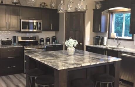 Custom two-tone granite kitchen island with black cherry wood cabinets