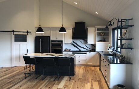 Custom black and white kitchen cabinets, countertops, kitchen islands, and stove hoods