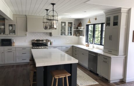 Custom white kitchen cabinets, countertops, kitchen islands, and stove hoods