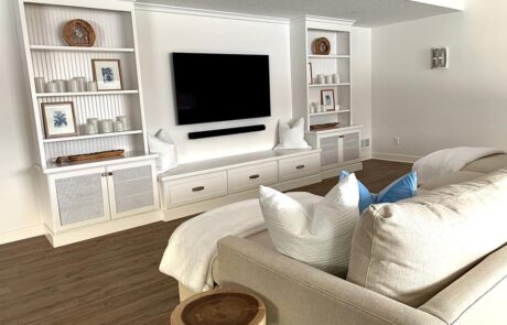 Custom cabinets for entertainment spaces including wooden TV console, bench, and decorative shelving