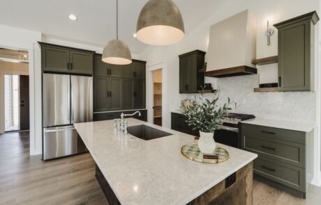 Custom kitchen interior featuring custom wooden kitchen cabinets, stove hood, and white granite countertops