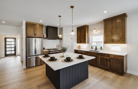 Custom kitchen cabinets, stove hood, stainless steel appliances, and marble countertops
